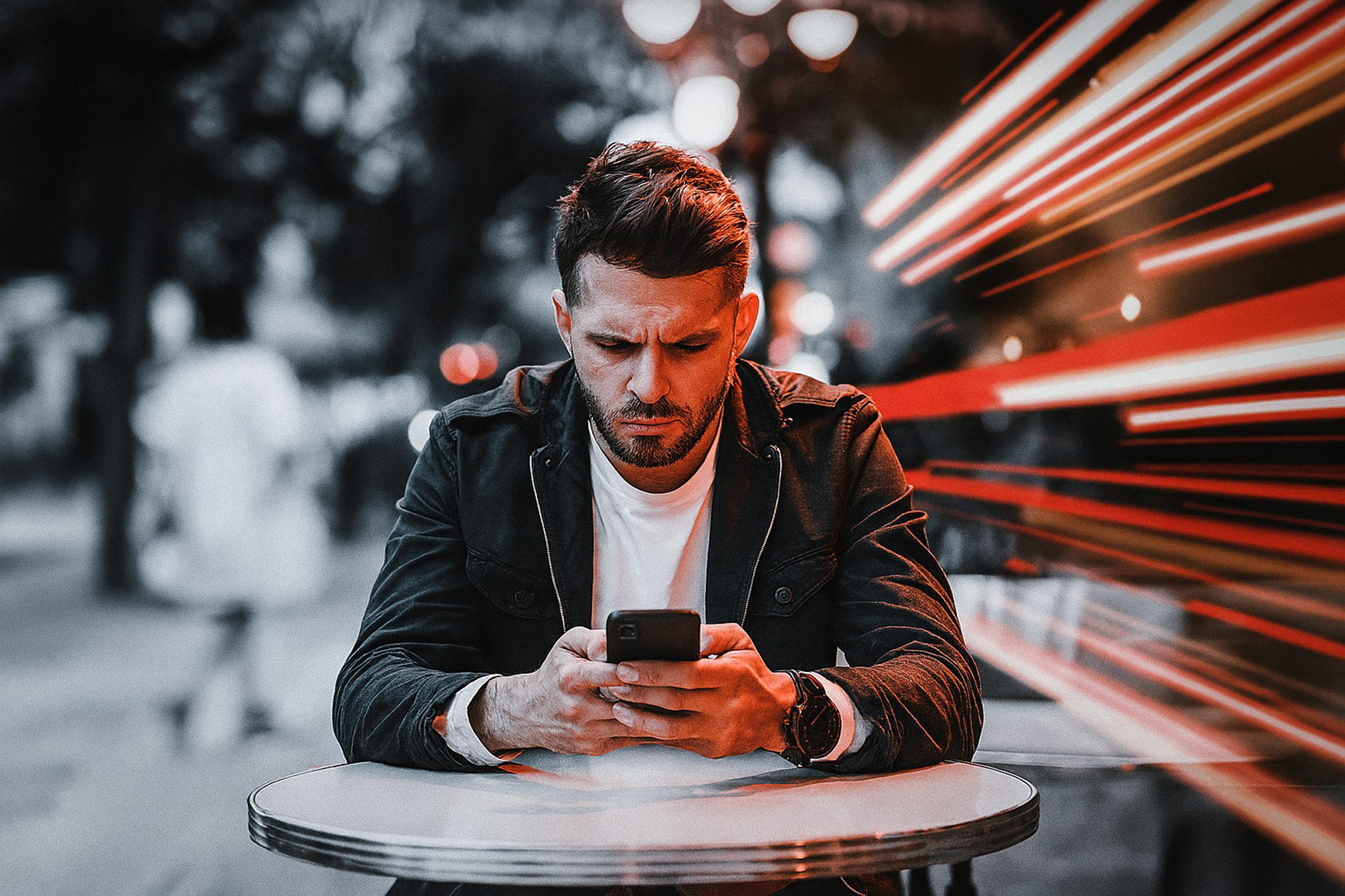 Homme assis seul à une terrasse, fixant son téléphone avec des messages de rejet en arrière-plan.